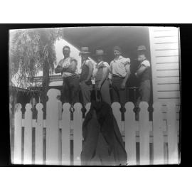Five men posed on a verandah with left sleeves rolled up
