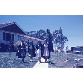 Students in academic robes on campus, UNE