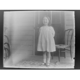 Smiling girl standing in front of a door
