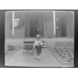Boy pulling a wagon down garden path