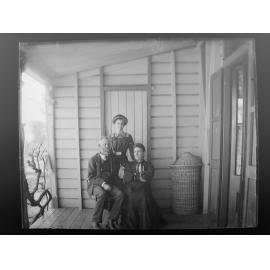 Mr, Mrs, and Miss Gunns stand on a verandah