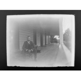 D. M. Cameron sitting on a verandah