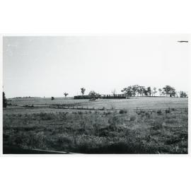View across a field towards the Wright College construction site, 1958