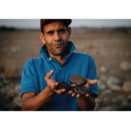 Colin Ahoy, UNE Archaeology student with local axe heads at the Gostwyck Grinding Grooves site, 2022