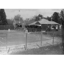 Photo of unidentified tennis court and houses