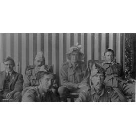 A group of soldiers wearing paper hats