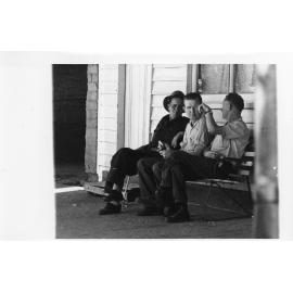 Three unidentified men on a seat