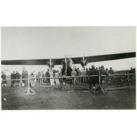 Ford Trimotor or Fokker aircraft and crowd