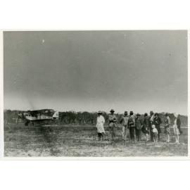 Group of people with aircraft in the background
