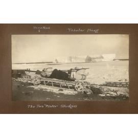 Two motor sledges at Cape Evans, showing a large tabular iceberg & the Terra Nova in the background