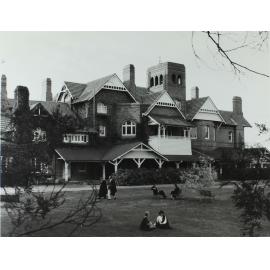 Booloominbah, southern side, students in gowns on lawns, c.1960