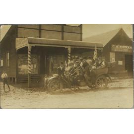 Men in car outside Cyril Benjamin, Tobacconist / Hairdresser