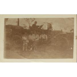 Family sitting on runningboard of motor car