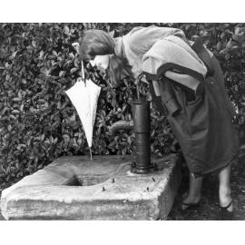 Student viewing water pump in the grounds of the Education Museum, c. 1975