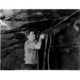 Andy Boundy drilling on the wall of the Damifino Mine with an impact jack hammer, c.1948
