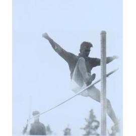 Male student going over a high jump