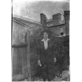 Unidentified woman standing at the rear of Mallam's Pharmacy, Beardy Street, Armidale