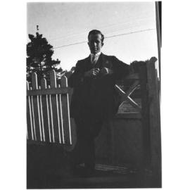 Man [with RSl badge] standing by the front gate of 63 Barney Street, Armidale
